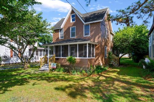 a brown house with a porch and a yard at The Mane Escape in Chincoteague