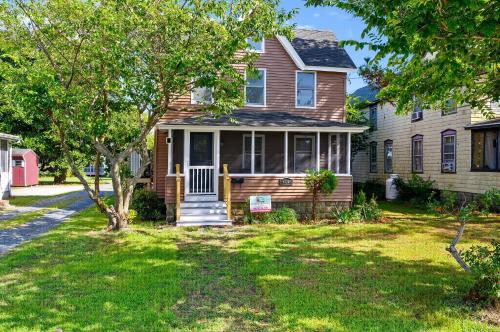 a house with a tree in a yard at The Mane Escape in Chincoteague