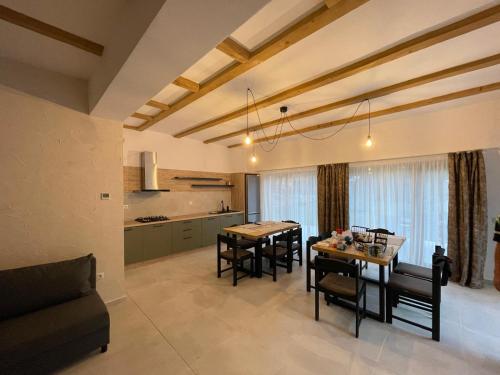 eine Küche und ein Esszimmer mit Tisch und Stühlen in der Unterkunft Pensiunea Carmen 1927 in Moieciu de Jos