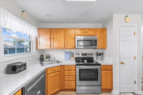 a kitchen with wooden cabinets and stainless steel appliances at Whispering Pines in Black Point Landing