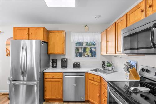 a kitchen with wooden cabinets and a stainless steel refrigerator at Whispering Pines in Black Point Landing