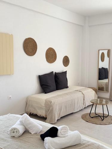 two beds in a white room with towels on the floor at Almyriki in Mylopotas