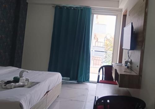 a bedroom with a bed and a television and a window at Akshay dream stay in Gurgaon
