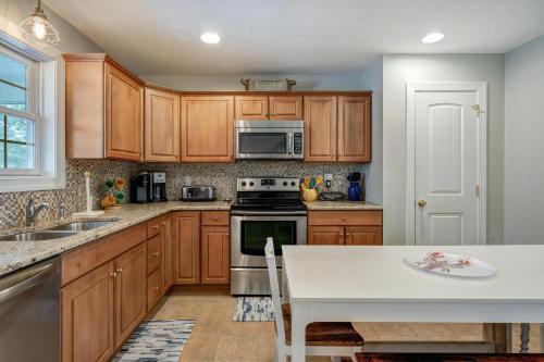 a kitchen with wooden cabinets and a white table at Eventide in Black Point Landing