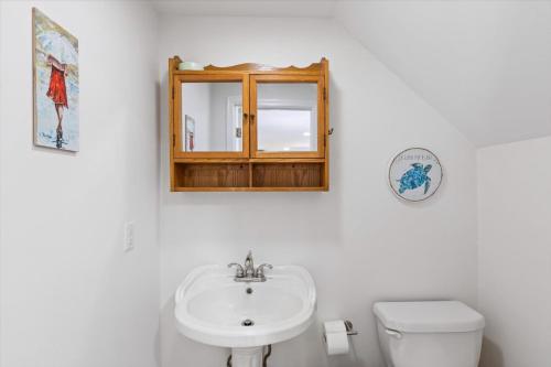 a bathroom with a sink and a toilet and a mirror at Precious Time in Chincoteague