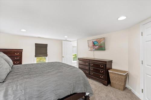 a bedroom with a bed and dressers and a window at Precious Time in Chincoteague