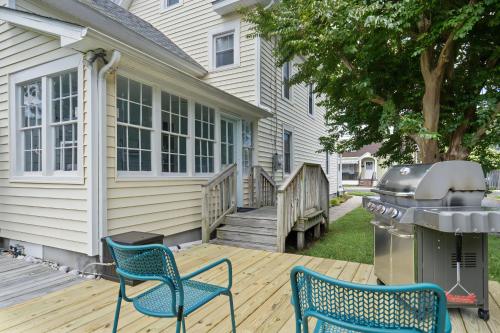 a deck with two chairs and a grill at Precious Time in Chincoteague