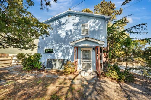une maison bleue avec une véranda arborée dans l'établissement Oyster Bay Oasis, à Deep Hole