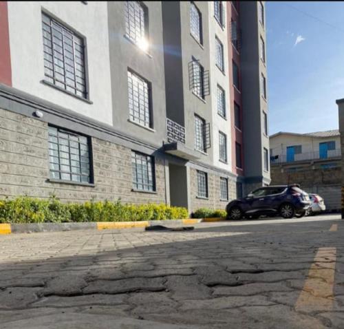 a car parked in front of a large building at Neema Homes Syokimau in Nairobi
