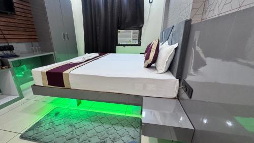 a bed in a room with green lights on the floor at Hotel bless inn in Bankipur