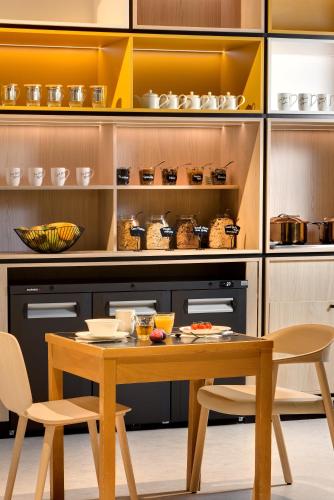a kitchen with a table and chairs in a kitchen at ibis Vichy in Vichy