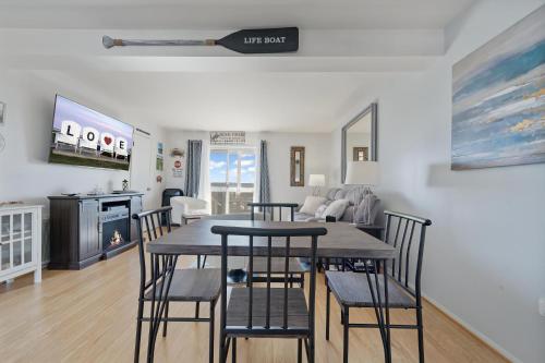 a dining room and living room with a table and chairs at Pony Swim Crossing in Black Point Landing