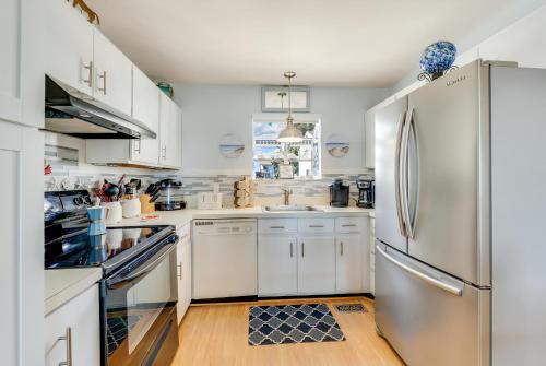 a kitchen with white cabinets and a stainless steel refrigerator at Pony Swim Crossing in Black Point Landing