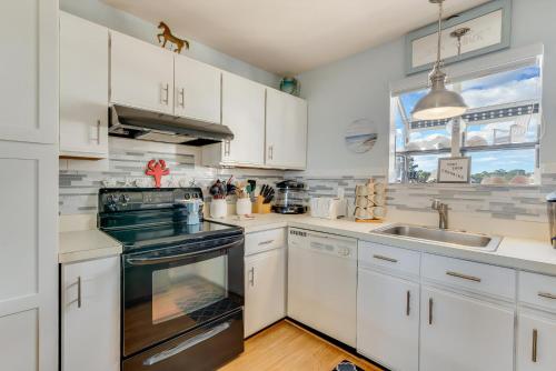 a kitchen with white cabinets and a sink and a stove at Pony Swim Crossing in Black Point Landing