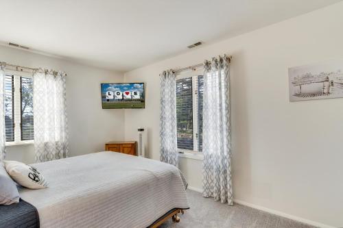 a bedroom with a bed and two windows at Pony Swim Crossing in Black Point Landing