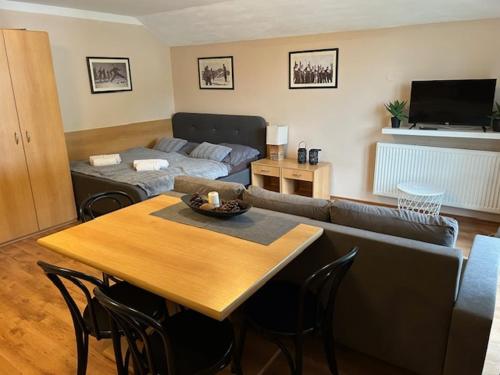 a living room with a table and a couch at Apartmány Gryf Harrachov in Harrachov