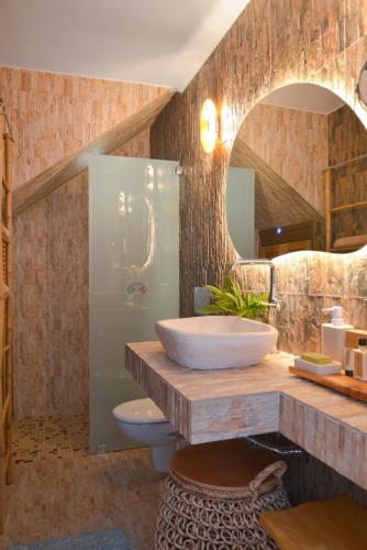 a bathroom with a sink and a toilet and a mirror at Miles Away Sifnos - Beachfront House in Platis Gialos