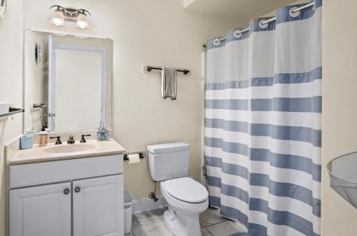 a bathroom with a toilet and a sink and a shower at Sunset Bay Villa 313 - By The Bay in Chincoteague