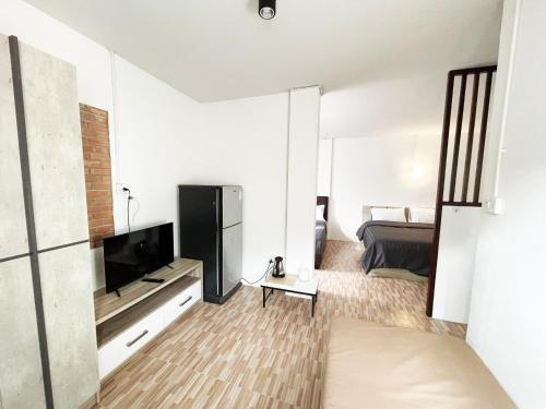 a living room with a television and a bed at 7HOUSE เซเว่นเฮ้าส์ - Racha caftel in Chiang Mai