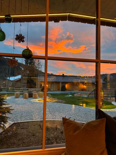 a view of a sunset seen through a window at Mariengut - Natur Aparthotel Kramer in Wagrain