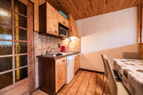 a kitchen with a sink and a table in a room at La Flèche d'Or in Châtel