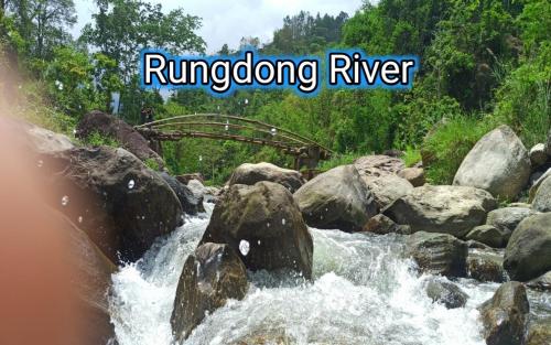 a river with rocks and the words jumping river at Angel Homestay in Darjeeling