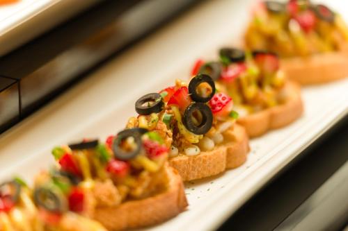 a group of small sandwiches with toppings on a plate at les suites taipei ching cheng in Taipei