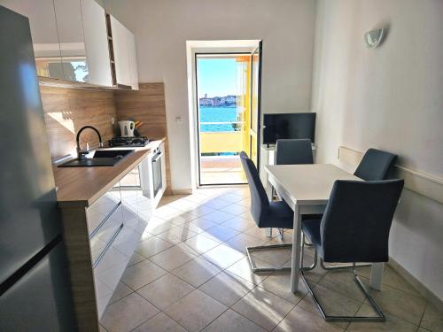 a kitchen and dining room with a table and chairs at Apartments Tudić in Brodarica