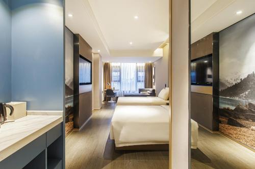a hotel room with two beds and a bathroom at Atour Hotel Chengdu Yulin Huaxi in Chengdu