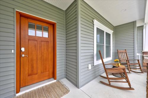 a wooden door on a house with two chairs at 116 Pine Forest Drive in Ocean Pines