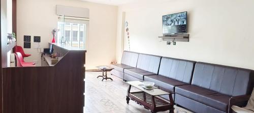 a living room with a couch and a table at Hotel Pergola - Mysore in Chāmundi