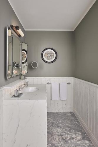 a white bathroom with a sink and a mirror at Villa San Michele, A Belmond Hotel, Florence in Fiesole