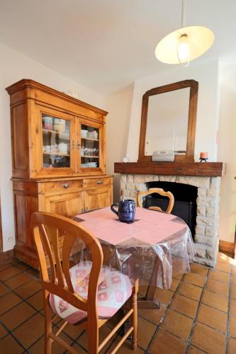 une salle à manger avec une table et une cheminée dans l'établissement Maison du GR34 - Baie de Beaussais, à Beaussais sur Mer
