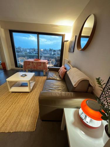 un salon avec un canapé et une table dans l'établissement Bel Horizon, au pied de la plage du Sillon, à Saint-Malo