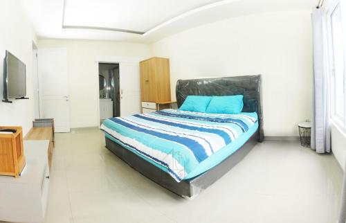 a bedroom with a bed with blue pillows on it at Hale lua Villa near Sanur Port in Sanur