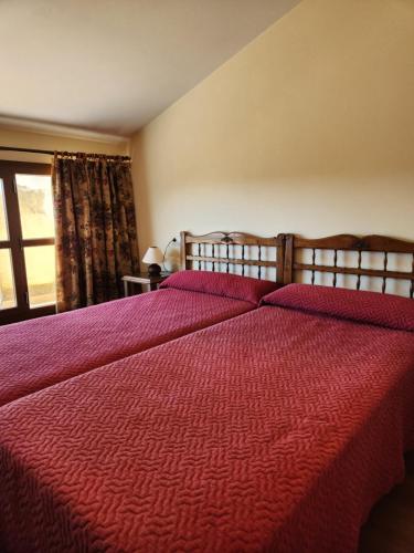 a bedroom with a large bed with a red comforter at Jayca in Trujillo