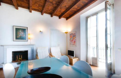 a living room with a glass table and a fireplace at Villa Lina in Lezzeno