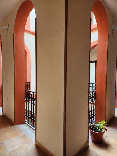 a hallway with arches and a plant in a pot at Jayca in Trujillo