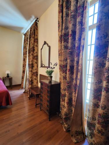 a bedroom with curtains and a dresser and a window at Jayca in Trujillo