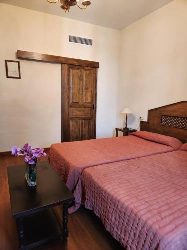 a bedroom with two beds and a vase of flowers on a table at Jayca in Trujillo
