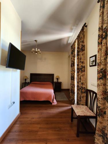 a bedroom with a bed and a flat screen tv at Jayca in Trujillo