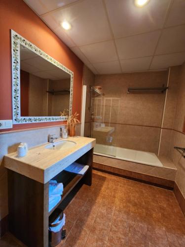a bathroom with a sink and a mirror and a tub at Jayca in Trujillo