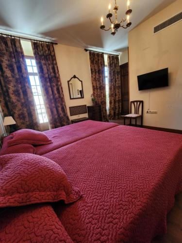 a bedroom with a large bed with a red comforter at Jayca in Trujillo