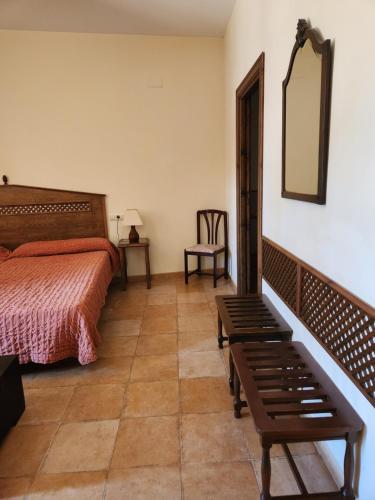 a bedroom with a bed and a mirror and a bench at Jayca in Trujillo