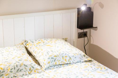 a bed with a pillow and a television in a room at Chalet Sésame à 5min des plages in Pouldreuzic