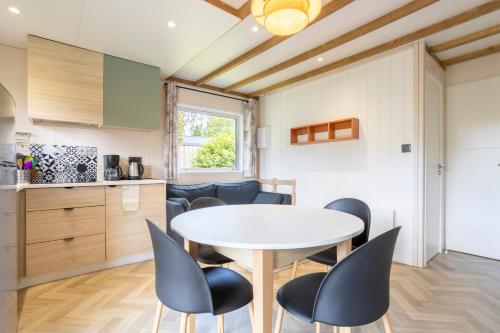 a kitchen and dining room with a table and chairs at Chalet Sésame à 5min des plages in Pouldreuzic