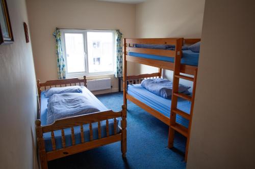 two bunk beds in a room with a window at Breakwater Hostel in Newquay