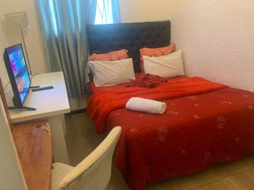 Un dormitorio con una cama con una manta roja. en The Napping Nook, en Ciudad del Cabo