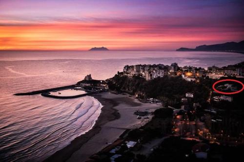 a view of a beach at sunset with a city at Villa Fiorella in Sperlonga