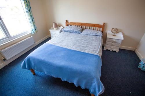 a bedroom with a large bed with a blue blanket at Breakwater Hostel in Newquay